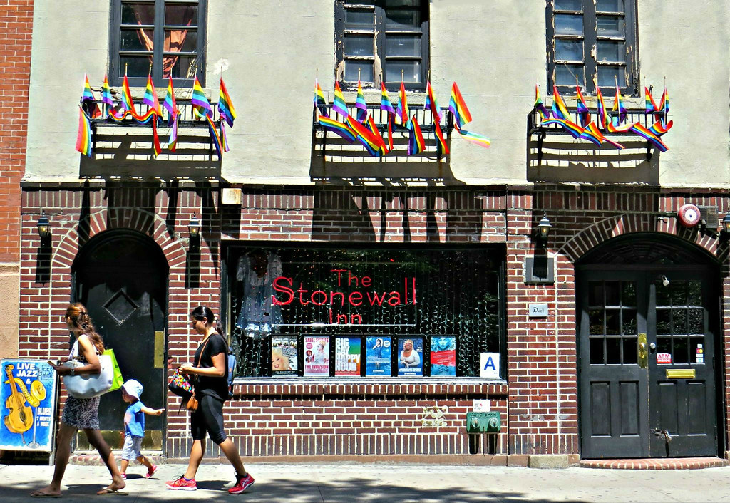 The facade of Stonewall Inn with Pride flags waving above it.