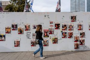 2T9F0NM Tel Aviv, Israel. 22nd Nov, 2023. A woman walks past a wall with posters featuring photographs of hostages held by Hamas in Tel Aviv. As the Israeli-Palestinian conflict continues, 13 Israeli hostages have been released on the 24 November from Gaza stripe. About 240 hostages have been held by Hamas in Gaza since the attack on Israel on 7th October. Credit: SOPA Images Limited/Alamy Live News