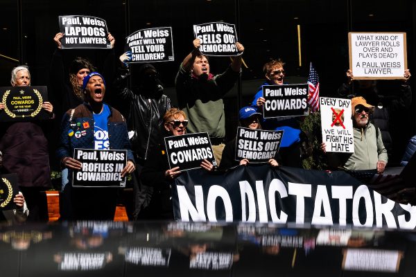 NEW YORK, NEW YORK - MARCH 25: People hold signs as they protest outside of the offices of Paul, Weiss, Rifkind, Wharton & Garrison LLP on March 25, 2025 in New York City. Activists held a protest at the law firm after the firm's managing partner Brad Karp reached a deal with the Trump administration to avoid litigation following an executive order targeting them. Karp agreed to give the Trump administration $40 million in free legal work for causes the president supports and to get rid of any internal diversity, equity and inclusion policies. (Photo by Michael M. Santiago/Getty Images)