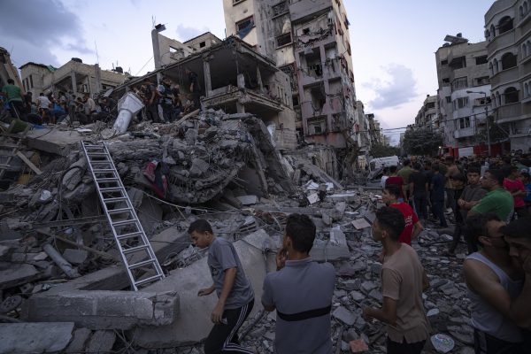 Palestinians look for injured in the rubble of a destroyed residential building following an Israeli airstrike, Tuesday, Oct. 10, 2023. The militant Hamas rulers of the Gaza Strip carried out an unprecedented attack on Israel Saturday, killing over 900 people and taking captives. Israel launched heavy retaliatory airstrikes on the enclave, killing hundreds of Palestinians. (AP Photo/Fatima Shbair)